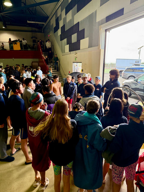 Coach Chris addressing a large group of swimmers at a meet